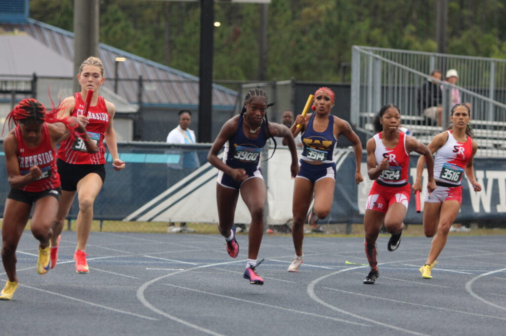 Xia Scott prepares to hand off the baton to Te'Ariel Harley for the second leg of the 4x100m relay race
