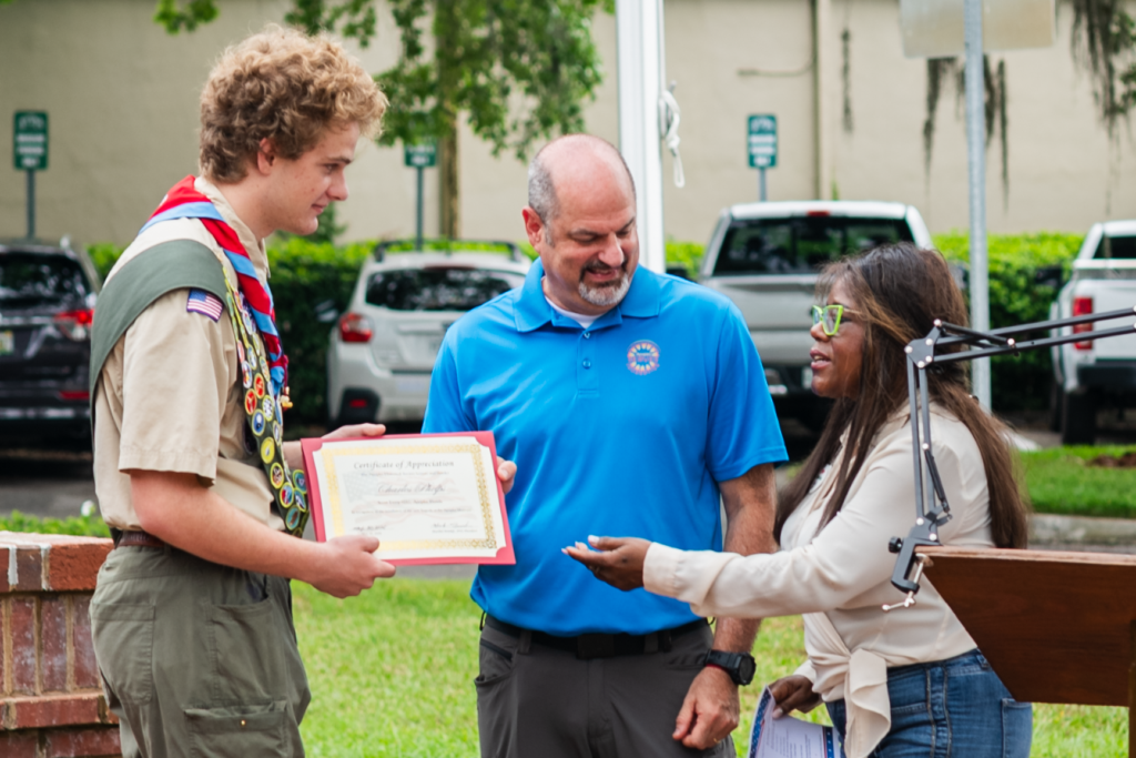 Eagle Scout candidate Charles Phelps (left) receives a certificate of appreciation from Chad Creech (center), board chair of the Apopka Serves Foundation, and Maribel Brinkle (right), president of the Apopka Historical Society, during Saturday's flagpole dedication ceremony at the Apopka Museum. Phelps led the service project that installed the museum's new flagpole.