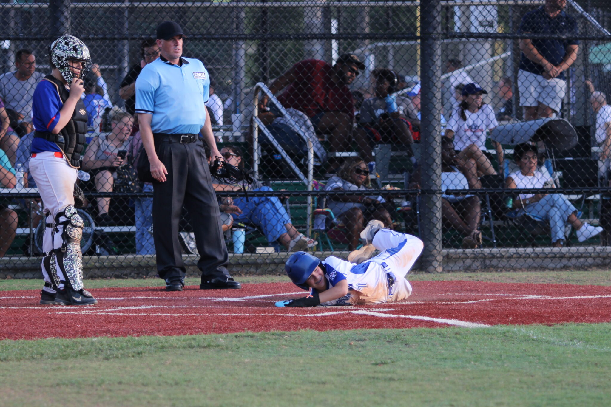 Brandon Ray flops onto home plate for a run.