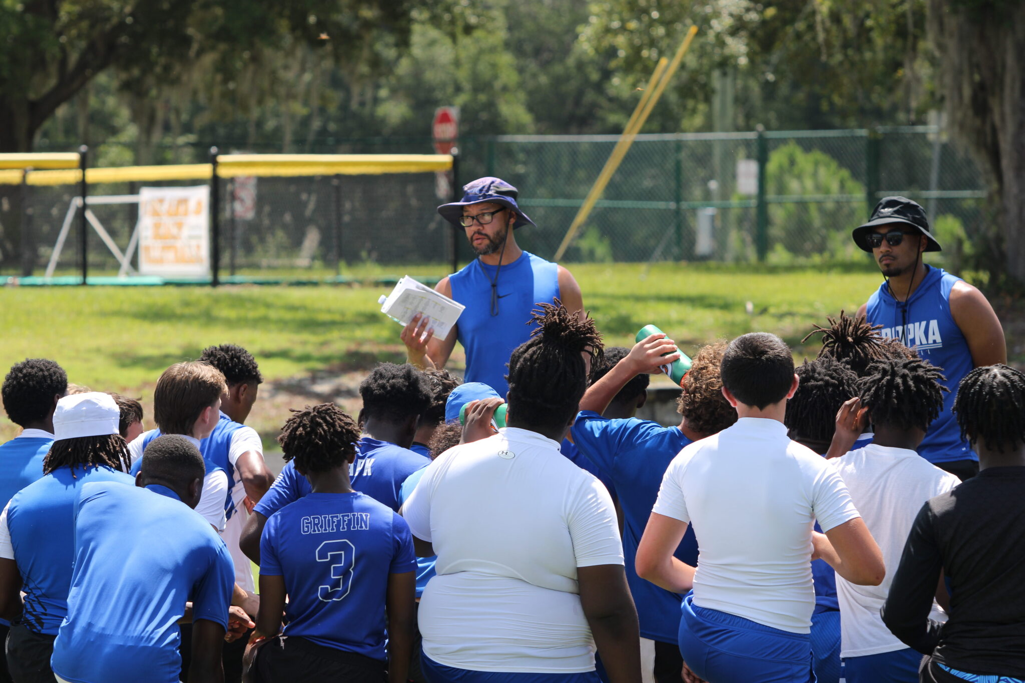 Coach Marcus Neeson talks to the team after 7-on-7 scrimmages at DeLand.