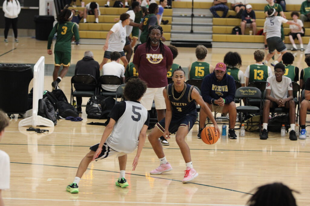 Eric Nichols dribbles at the wing as he looks for an open man in front of coach Lubin.
