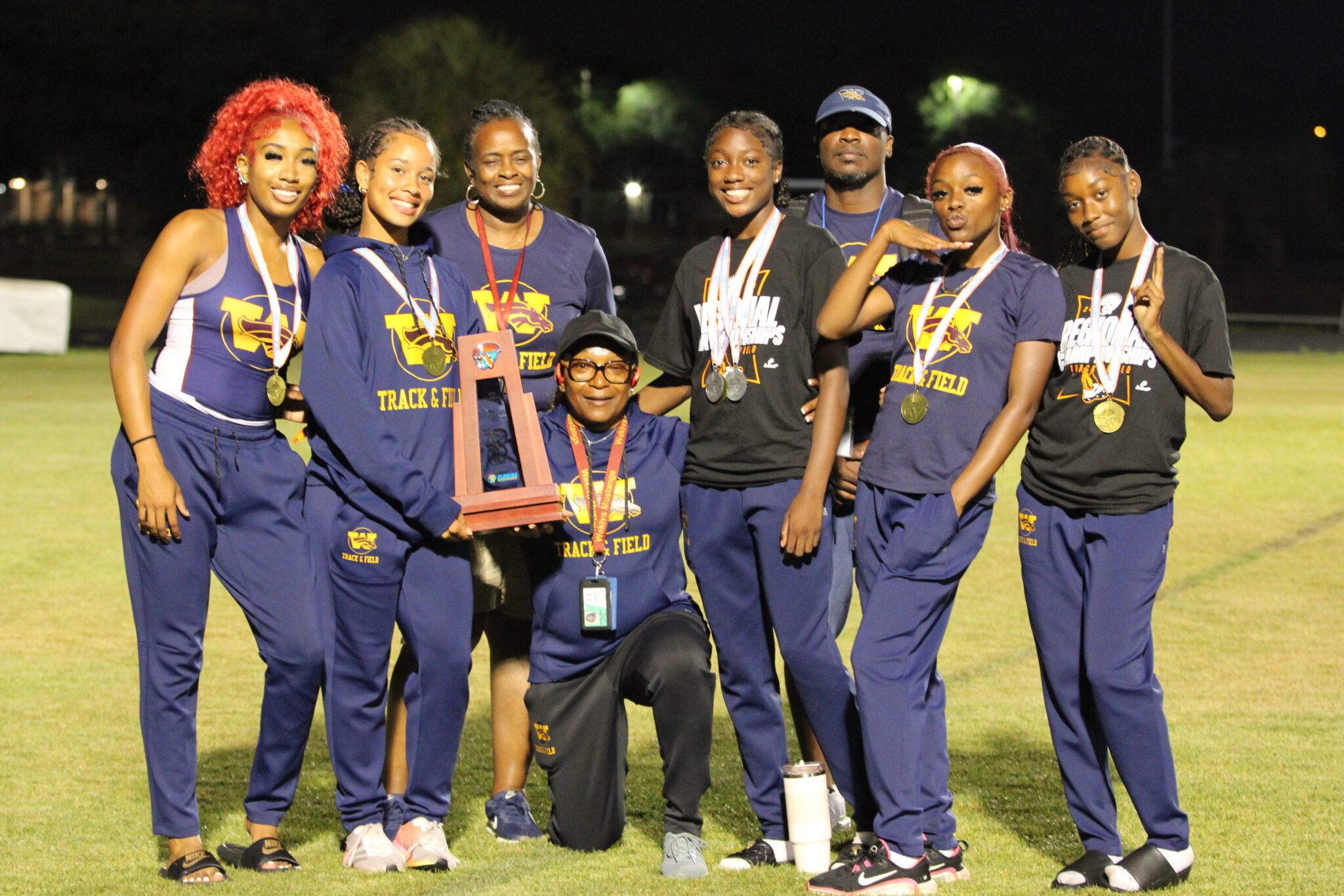 Lady Mustangs Track and Field poses with Regional trophy