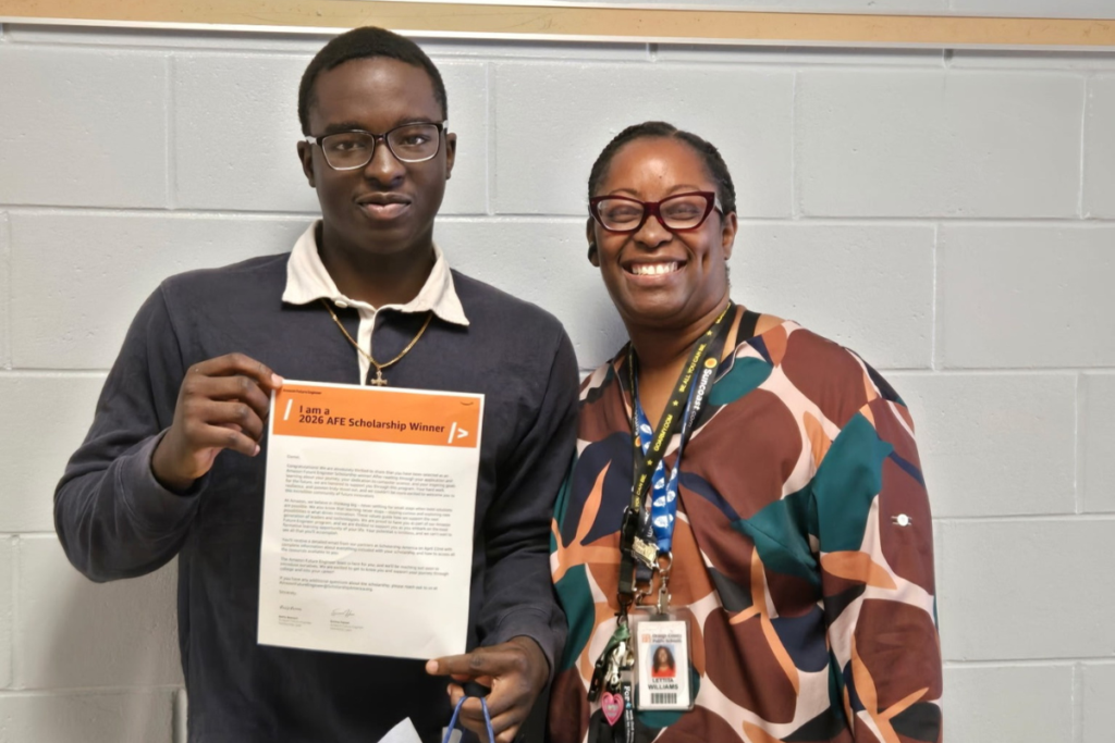 Daniel Idowu poses with Lettita Williams and a congratulatory letter from Amazon.