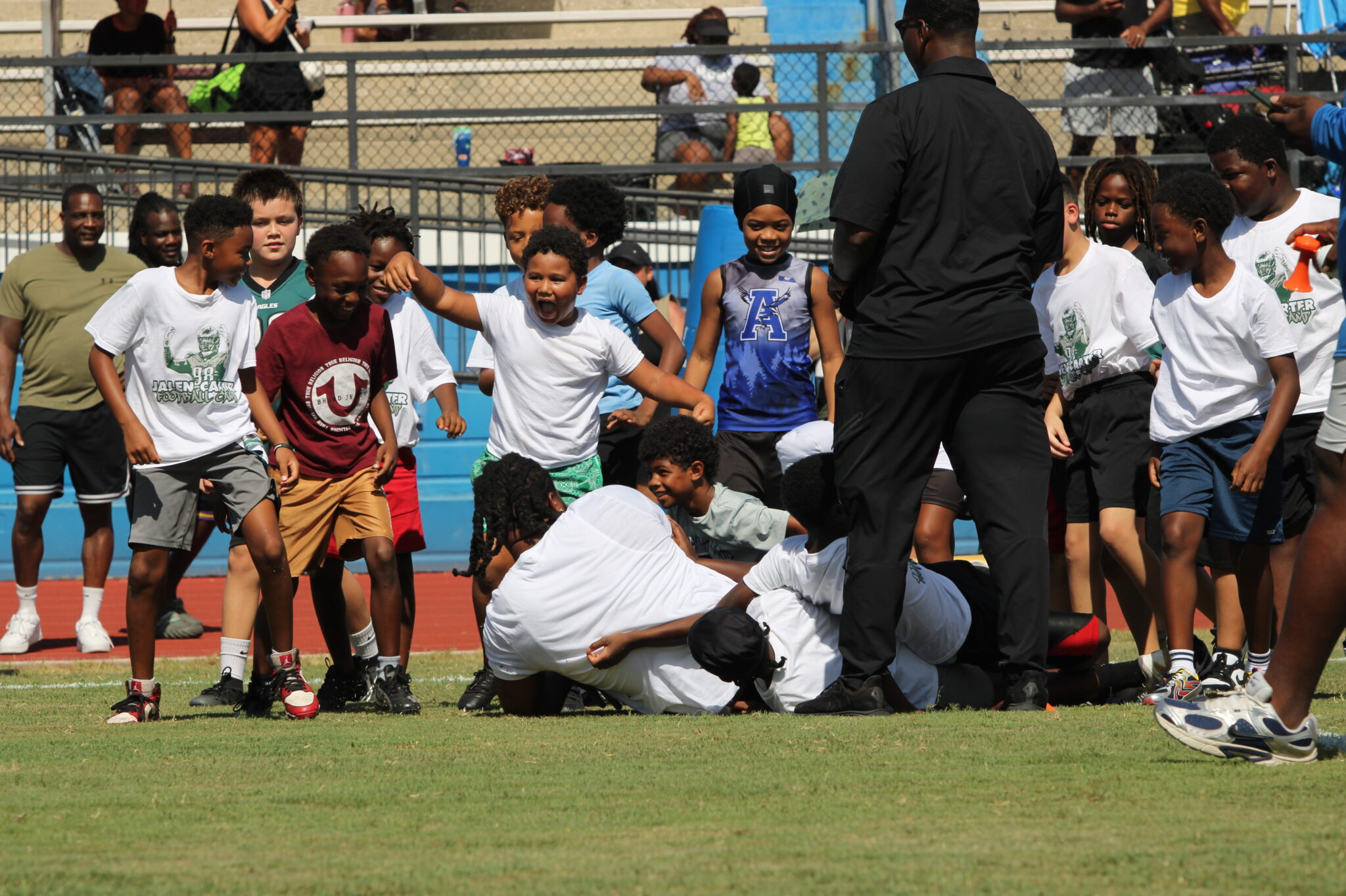 A group of campers take down Jalen Carter and dog pile on top of him during camp.