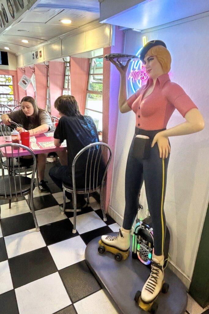 A statue of a carhop stands near one of the entrances at Angel's Diner.