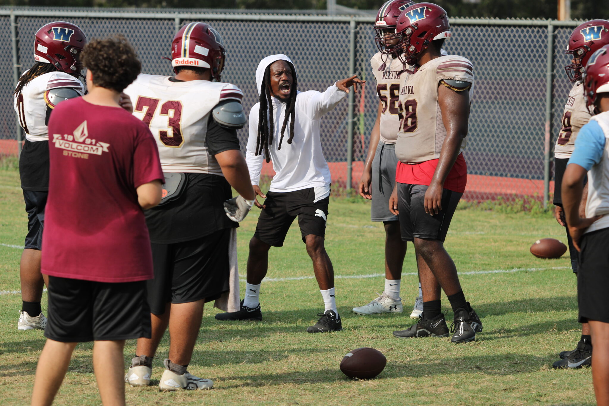Coach Gates instructs the offensive line on pre-snap callouts and adjustments.