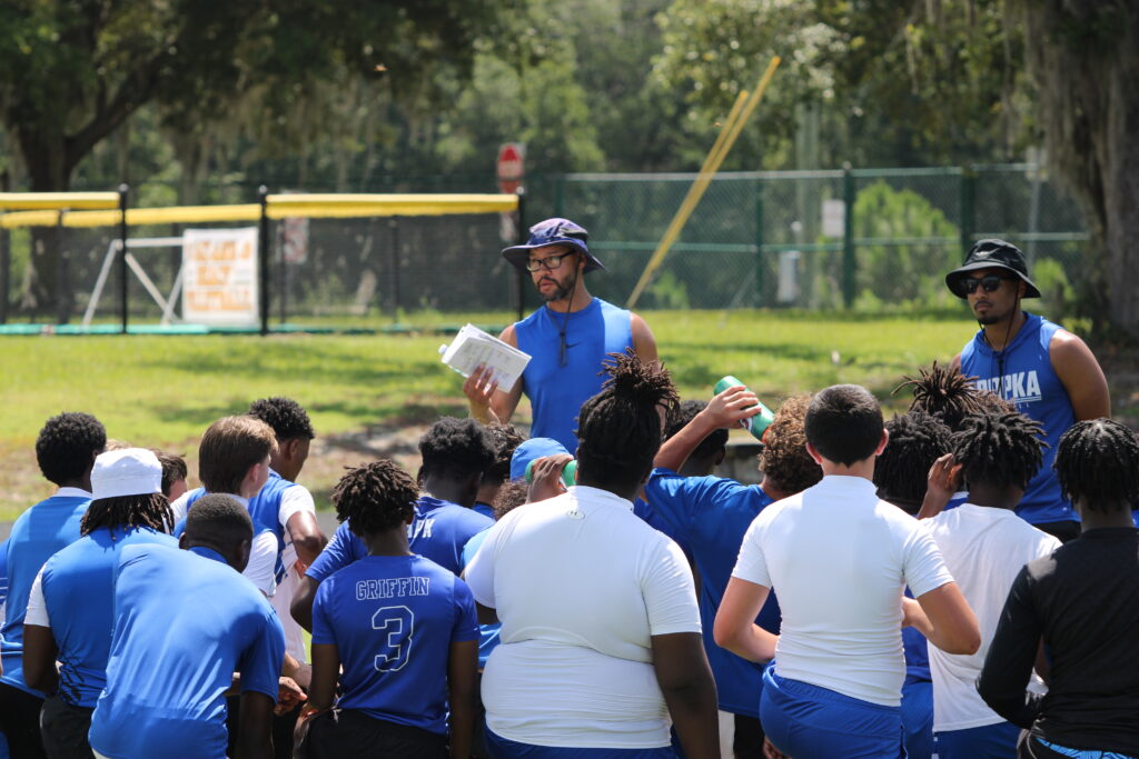 Coach Marcus Neeson talks to the team after 7-on-7 scrimmage at DeLand.