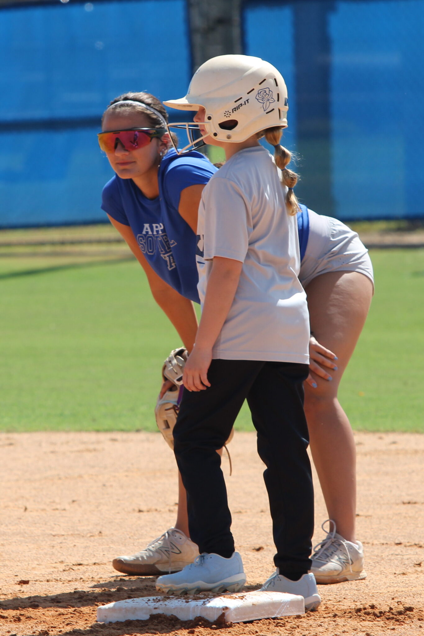Junior Callie Sowers talks with a young camper at second base on Wednesday during the Apopka Softball camp.