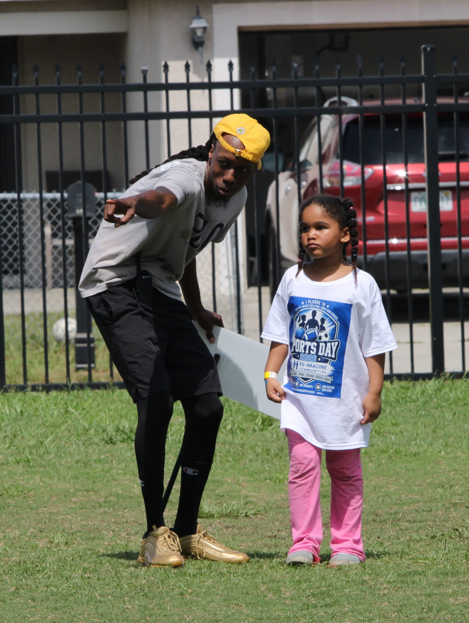 Mel Bolden guides and instructs a young competitor on where to run next in kickball.