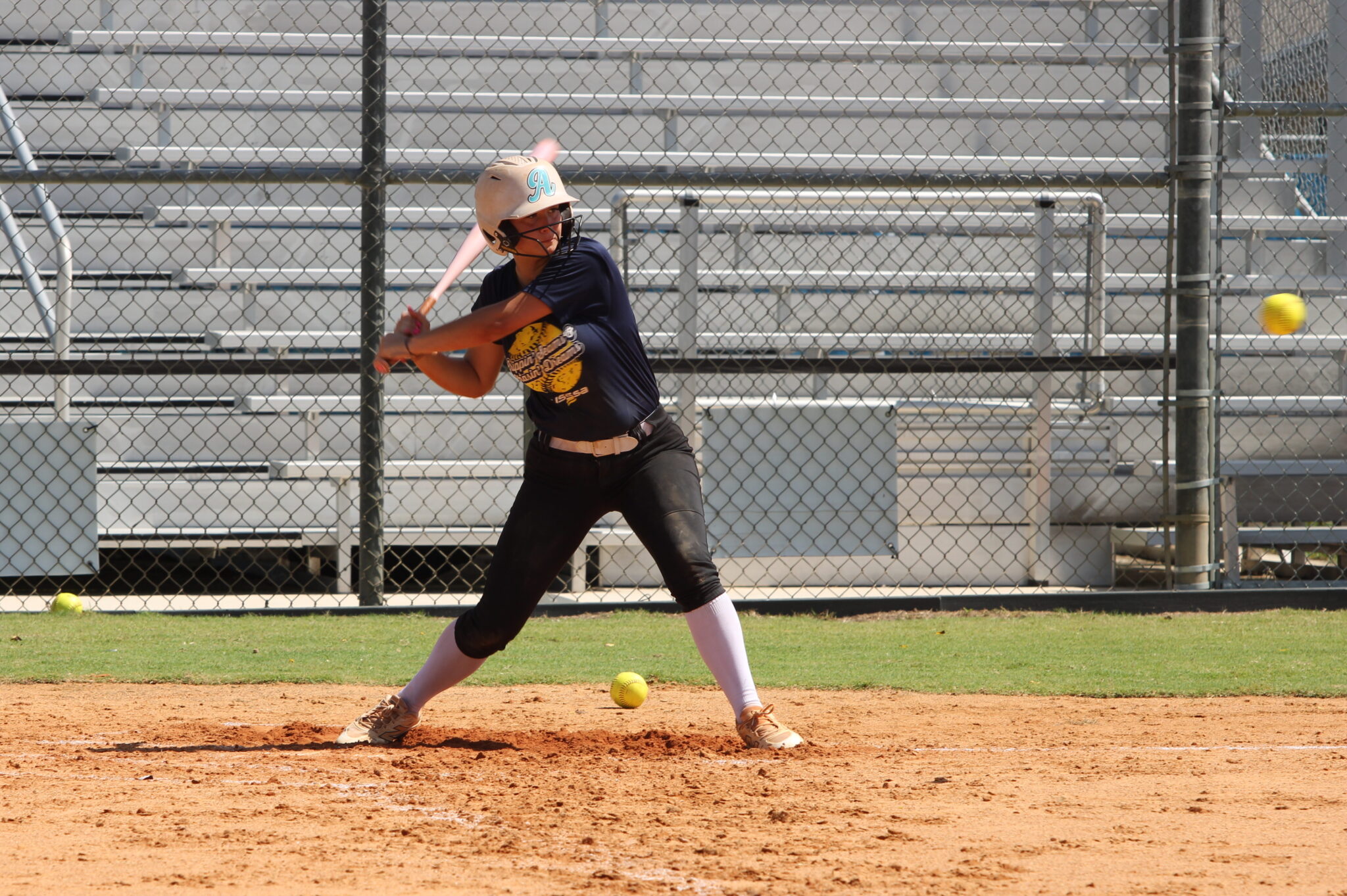 Older camper and incoming freshman smokes a soft toss pitch over the high school fence on Wednesday at the Apopka Softball camp.