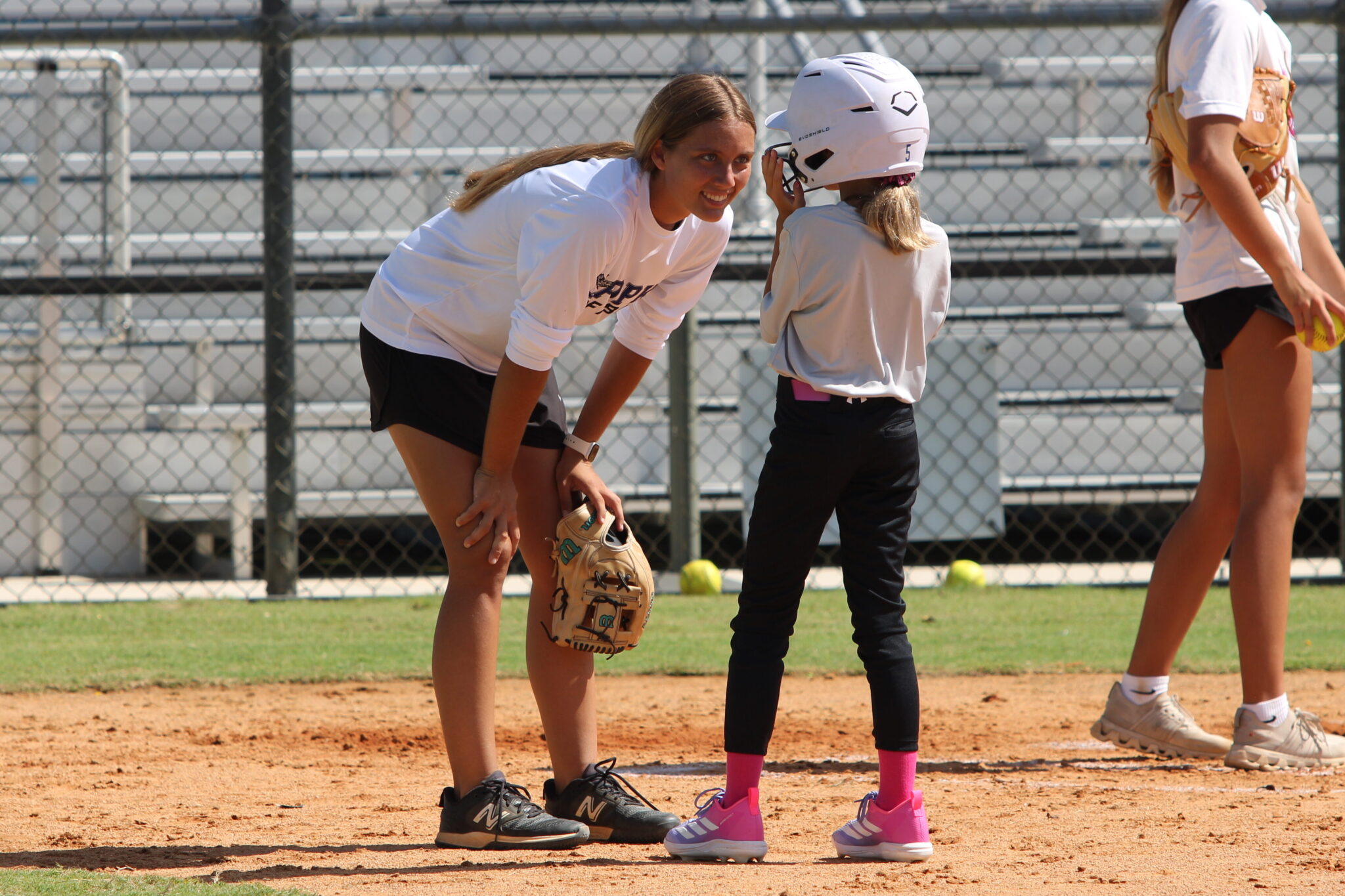 Senior Ava Gonzalez gives a young camper some encouragement on their trip to the plate on Wednesday during the Apopka Softball camp.