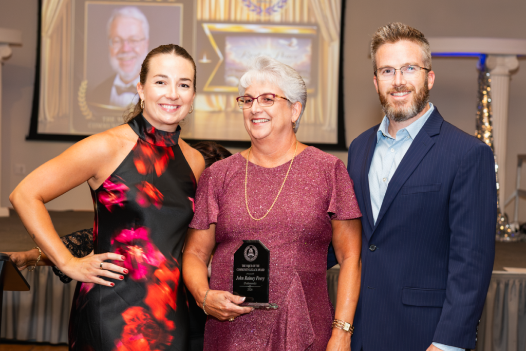 Kristin Peery Martin (left), Grace Peery and Adam Shaw pose with the Voice of the Community Legacy Award after accepting the posthumous honor on behalf of John Rainey Peery during the Apopka Sports Hall of Fame Induction Gala on Saturday at the Apopka Community Center. Martin is John and Grace Peery's daughter, and Shaw is Grace Peery's son and John Peery's stepson.  