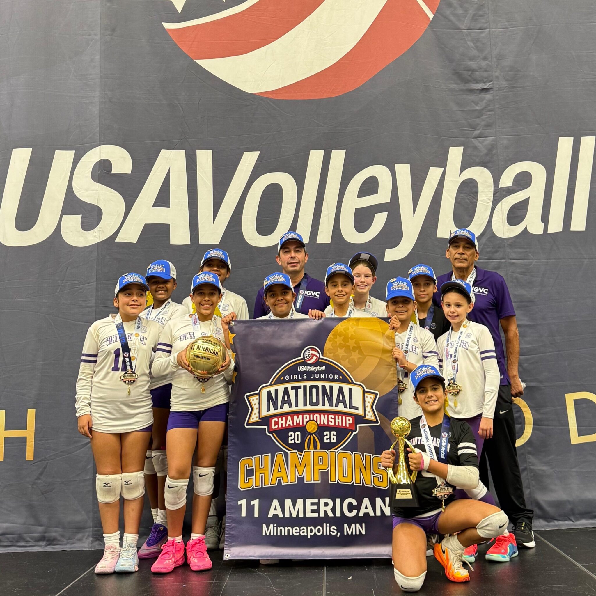 Winter Garden Volleyball poses together with their hats, medals, and trophy at the USA Volleyball Junior National Championships.
