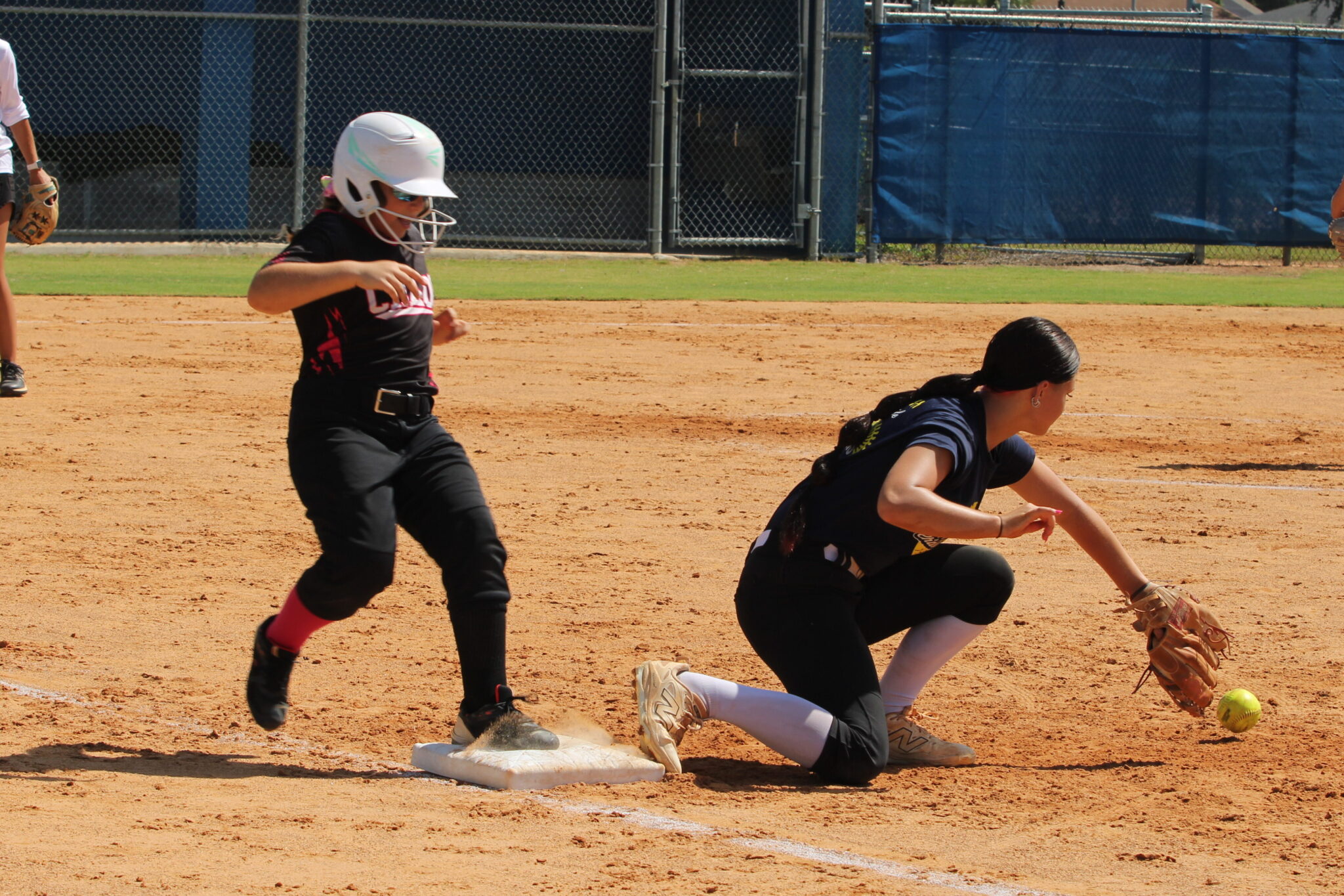 Young camper plants her foot on first base safely during the soft toss hitting session on Wednesday at the Apopka Softball camp.