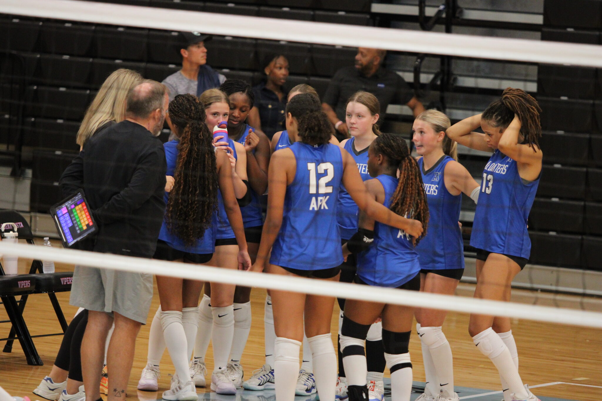 Apopka Blue Darters girls volleyball team huddles up in between sets against Lake Buena Vista.