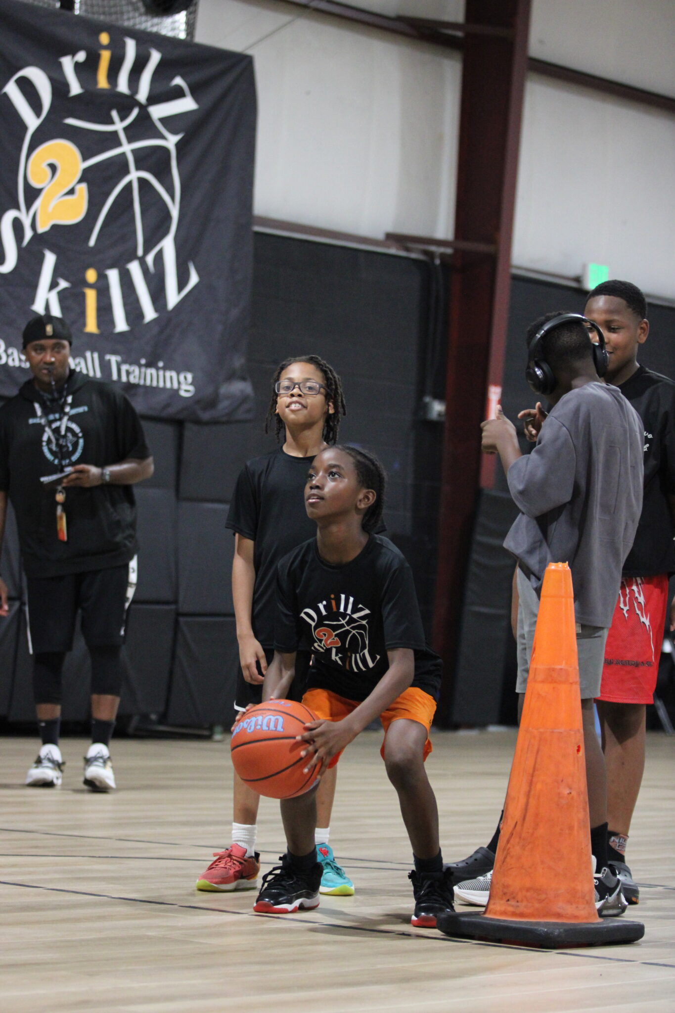 Campers line up for the free throw competition as Mark Washington watches on.