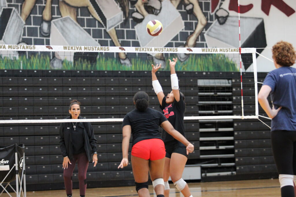 Coach Heather Lorenz instructing proper kill form as Isabella Espada sets her teammate.