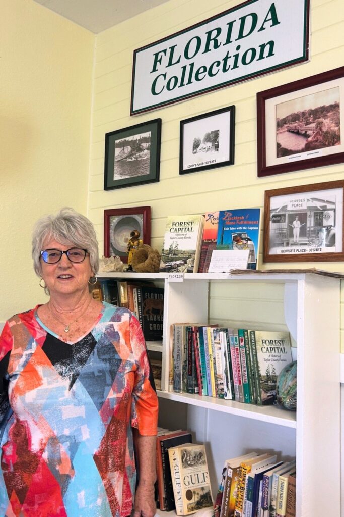 Debra Butler, a member of the Steinhatchee Chamber of Commerce board, at the Little House Library, which she manages.