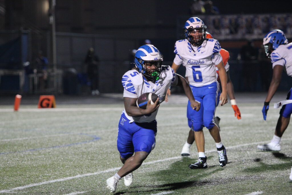 Jalen Parmely carries a handoff to the right.