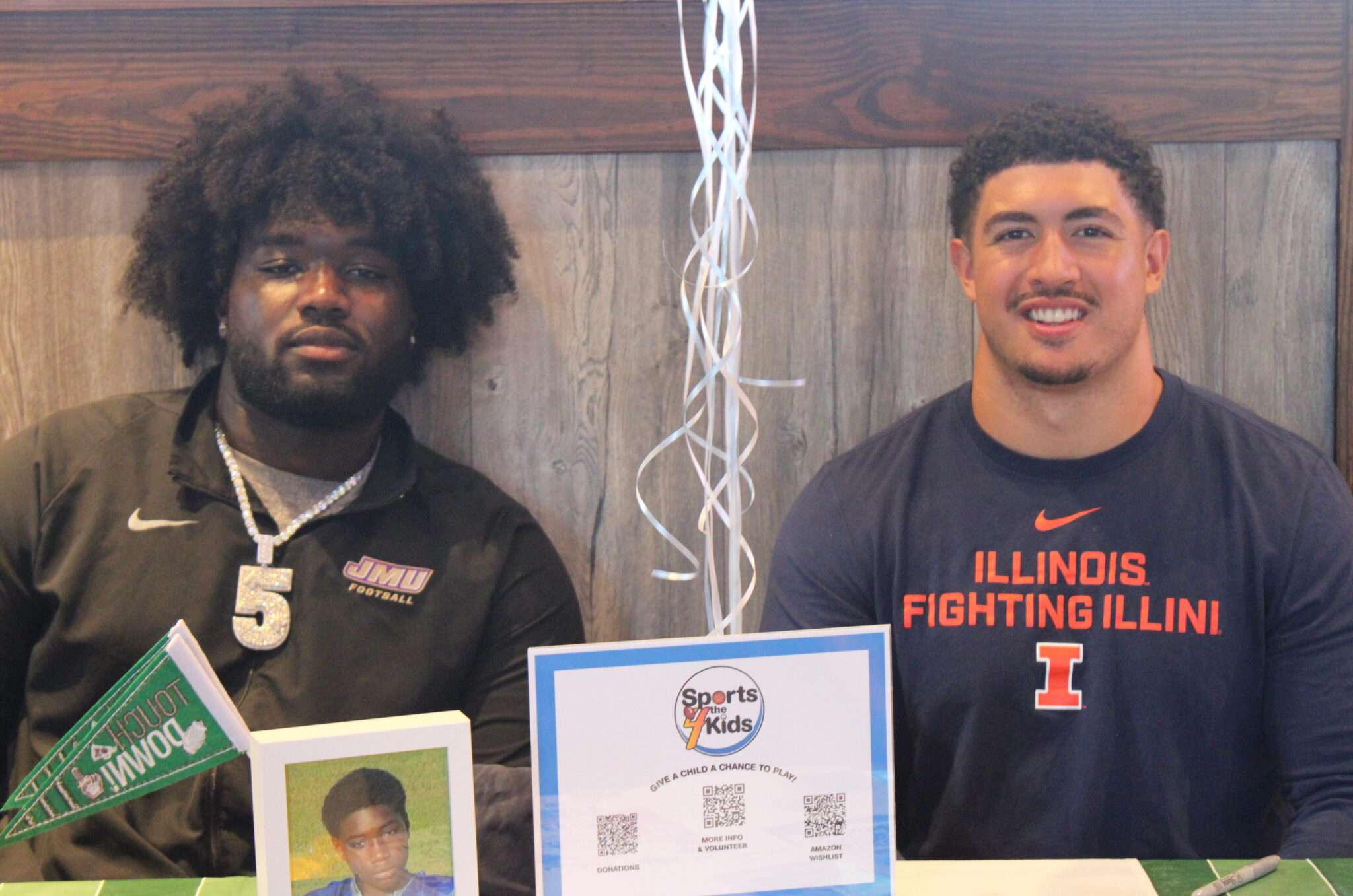 Kevin Roberts (L) and Kingston Shaw (R) pose for a picture at the Influencer Counsel's Pop Warner giveback event at Zaxbys.