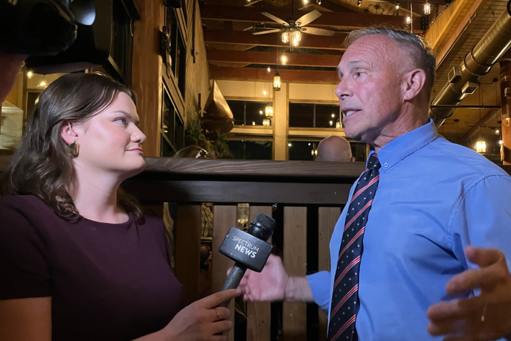 Chris Messina speaks with a reporter Tuesday night at his Orange County mayoral election watch party. Messina advanced to a November runoff against Tiffany Moore Russell, according to unofficial results.