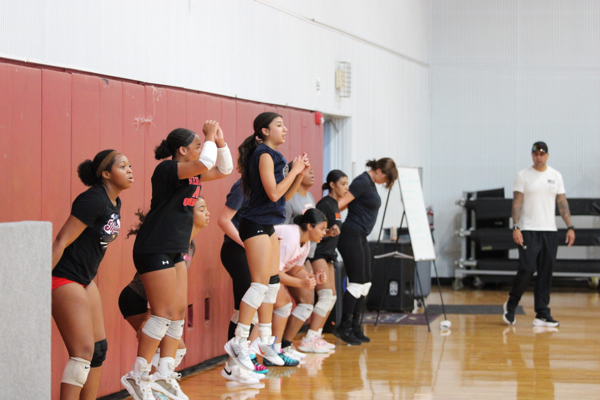 Mustangs Varsity group does squat jumps as a part of Orlando Fire Dept. firefighter Ely Sanchez's team workout.