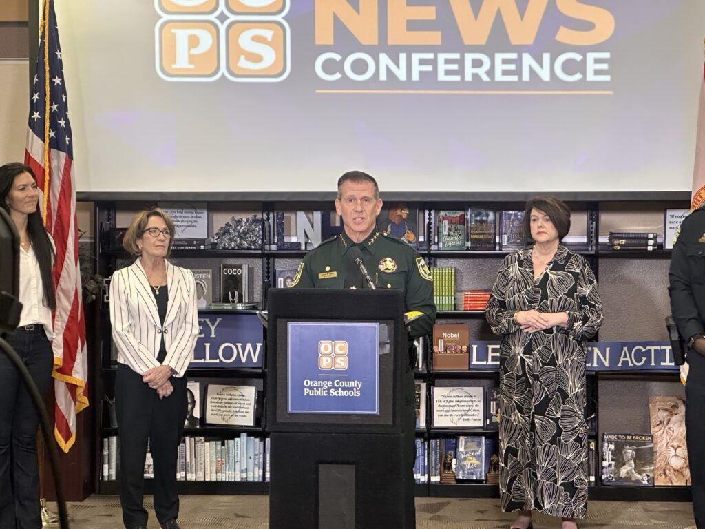 Orange County Sheriff John Mina speaks at podium during OCPS back-to-school news conference at Lake Nona High School