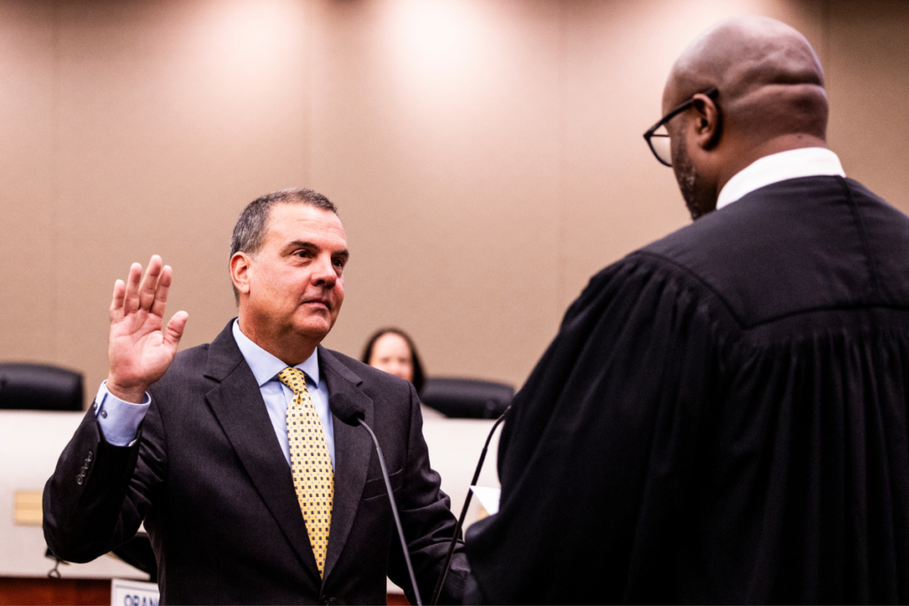 Orange County District 2 Commissioner Michael “Mike” Crabb (L) takes the oath of office from Ninth Judicial Circuit Judge Andrew Bain (R) on Tuesday, Aug. 25, at the Orange County Administration Center. Crabb was sworn in shortly before taking his seat for his first Board of County Commissioners meeting.