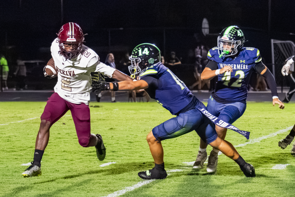 Bakary Manley (2) stiff arms the incoming defender.