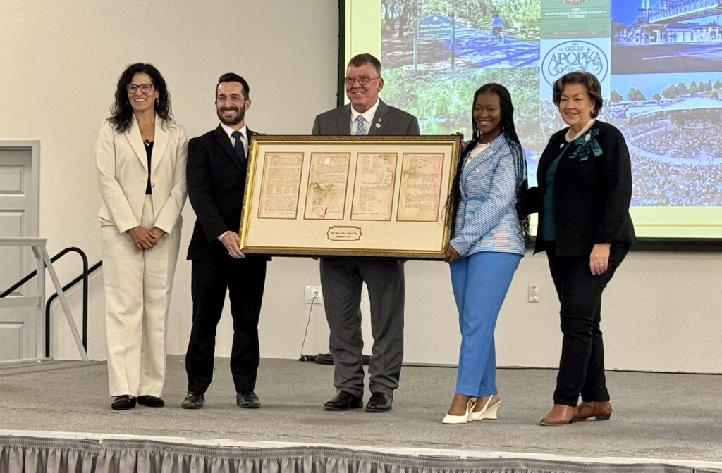 From left to right: Commissioner Yesenia Baron, Mayor Nick Nesta, Commissioner Sam Ruth, Commissioner Nadia Anderson and Vice Mayor Diane Velazquez pose with Apopka's original incorporation papers.