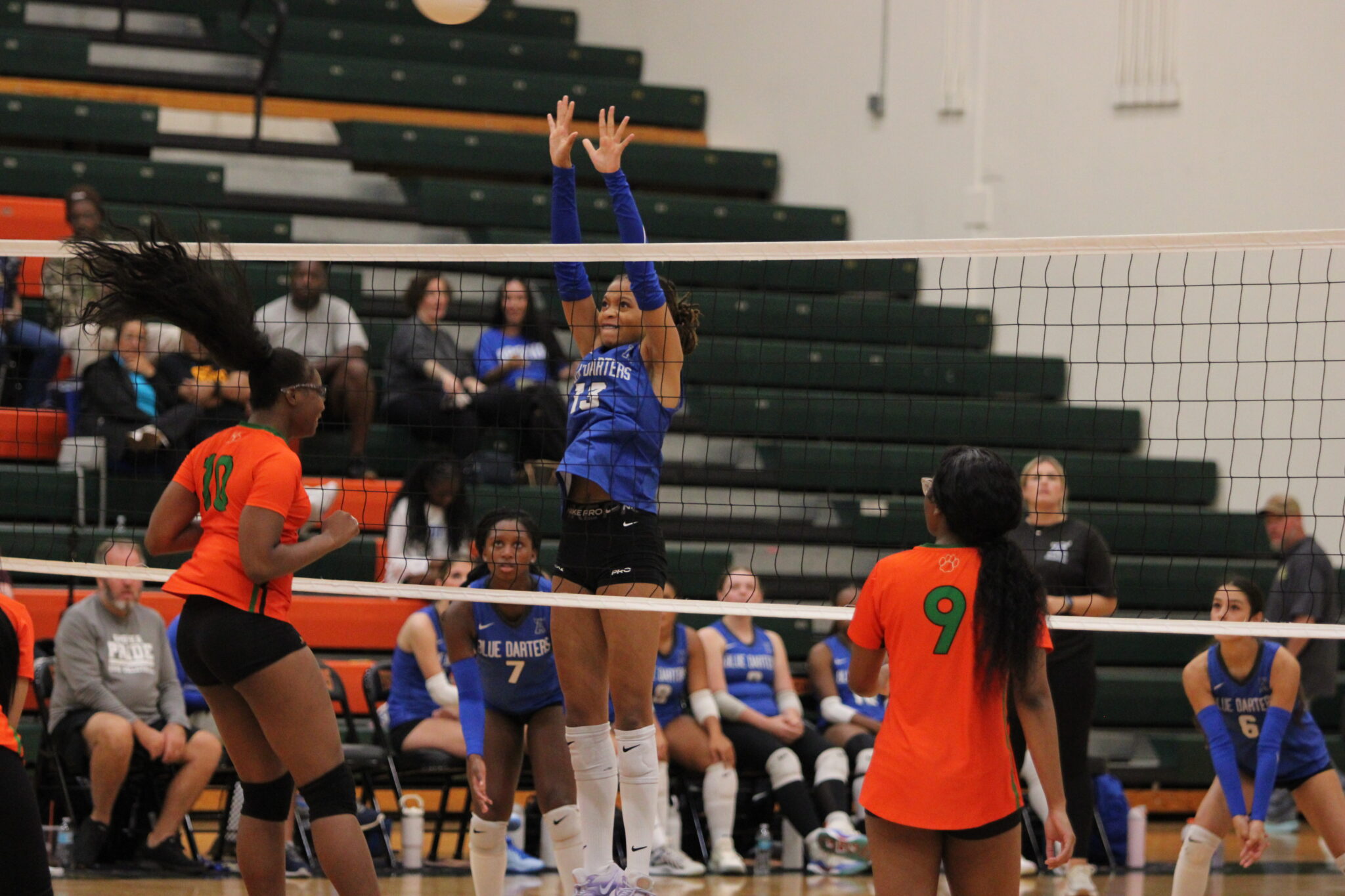 Kierra Taylor reaches up at the net in attempt to block a ball.
