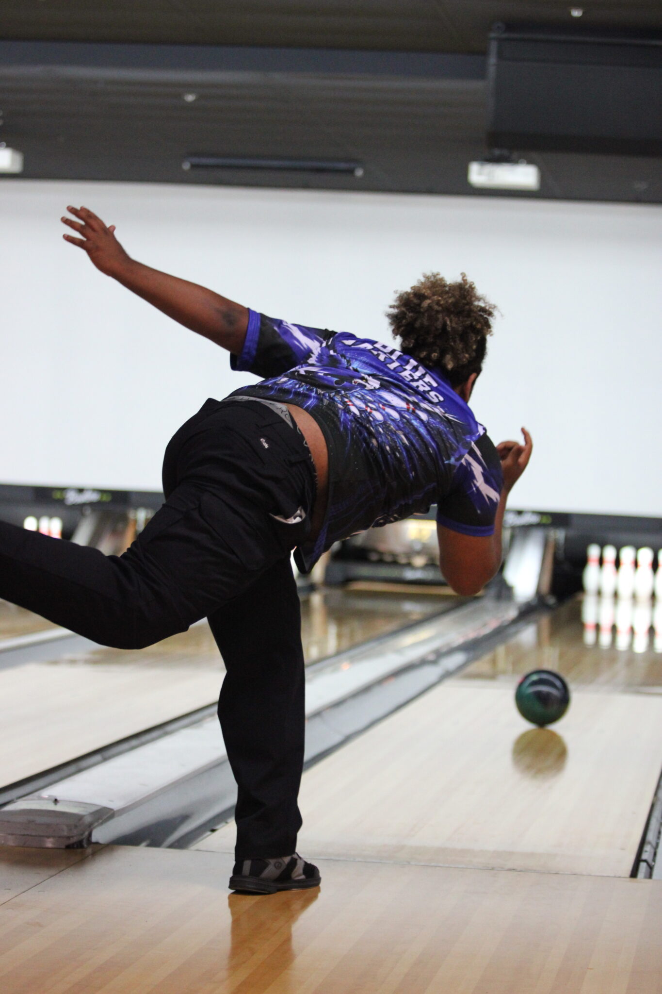 Maven Cardenas flicks his wrist and watches his ball spin through the lane.