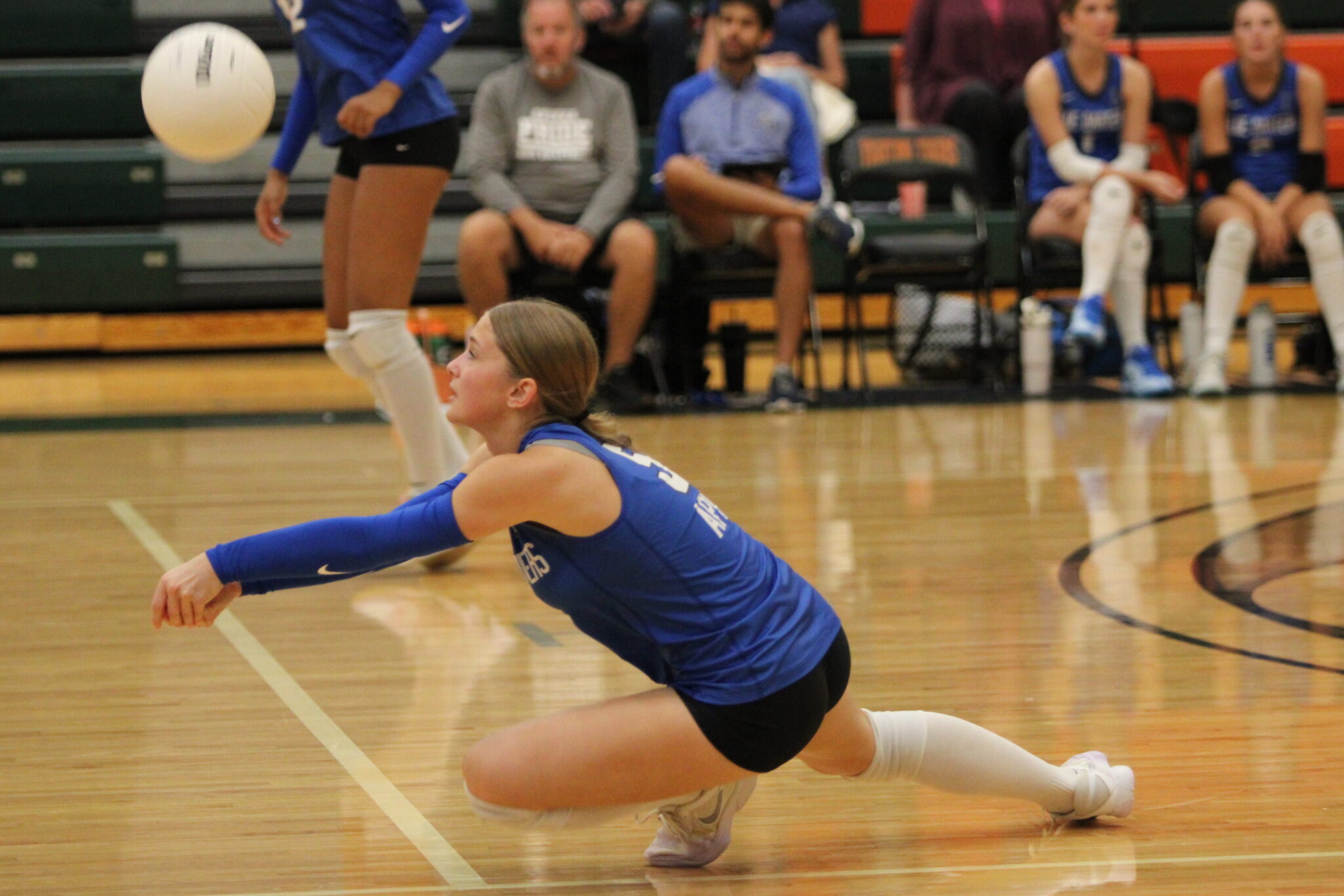 Victoria Polusmak dives forward to receive a short serve.