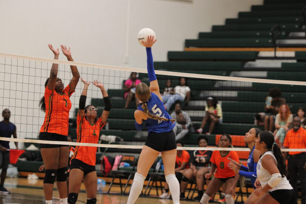 Victoria Polusmak rises up to spike a ball from the left side of the net.