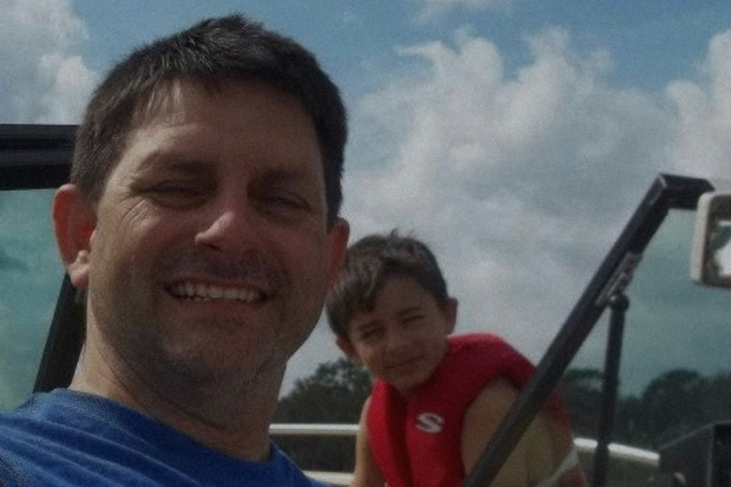 Daryl Hill (left) poses with his son Dawson Hill (right) on a boat.