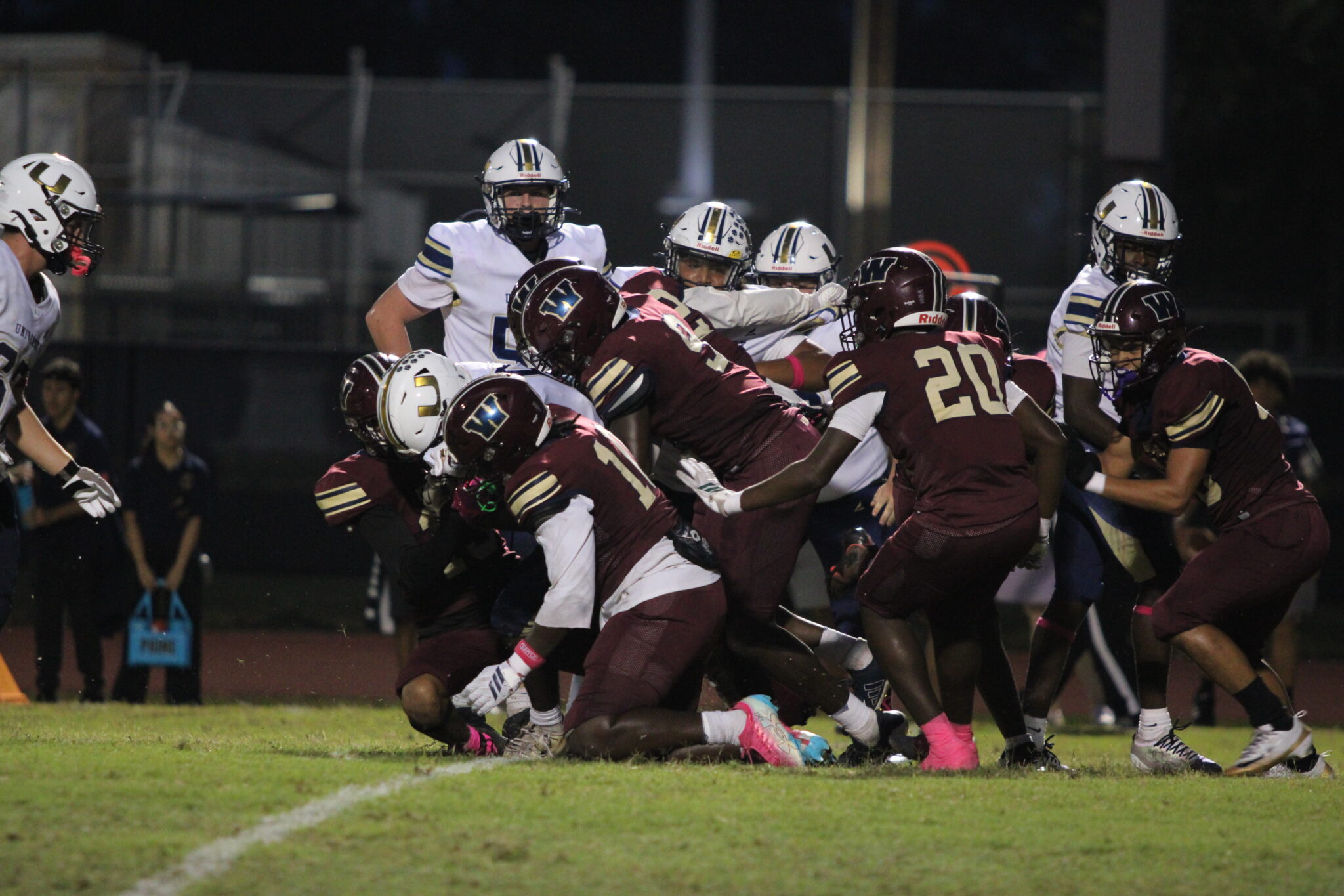 A herd of Mustangs tackle the University ballcarrier.