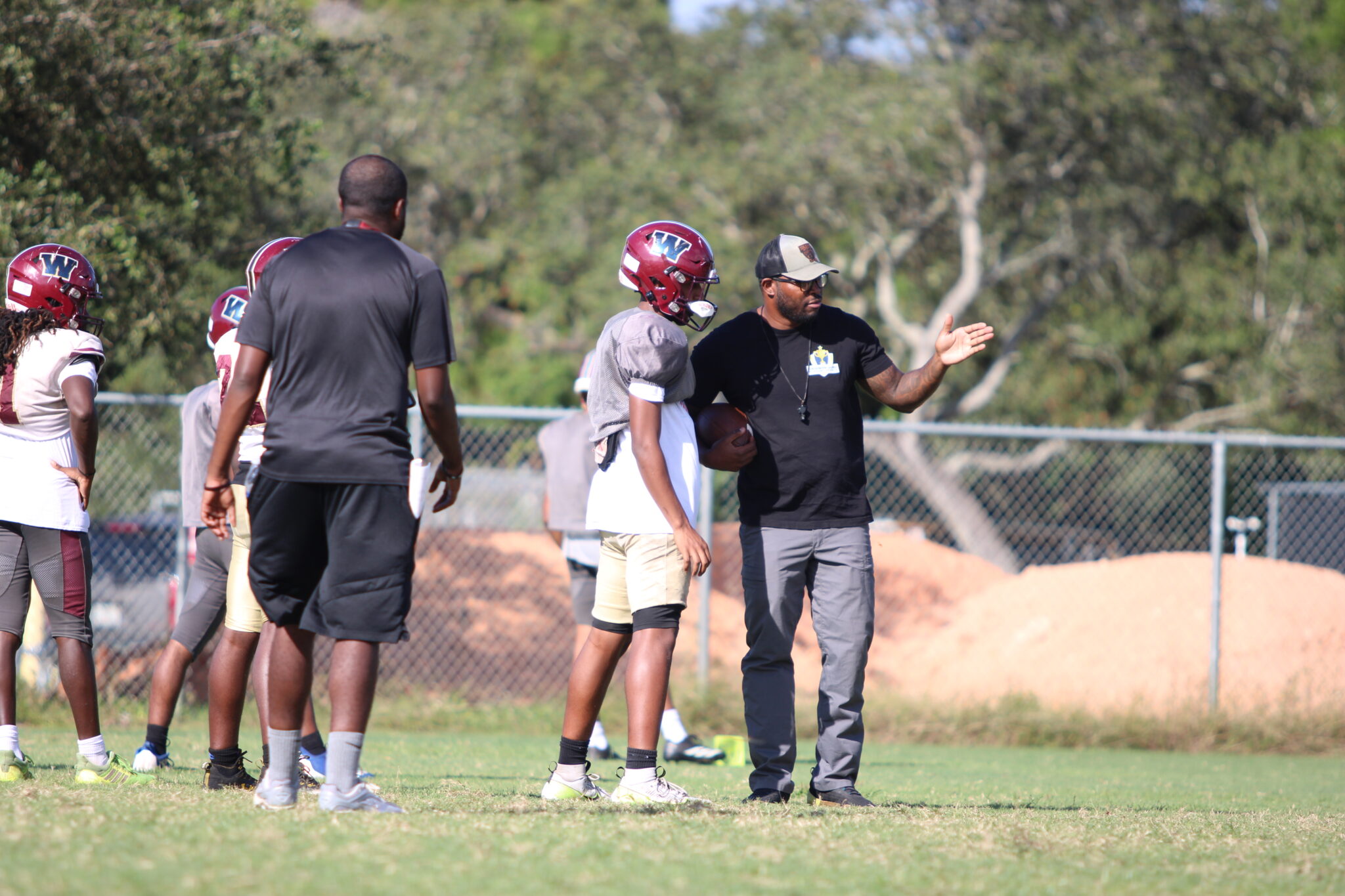 Coach Brandin Hawthorne coaching up one of Wekiva's pass rushers.