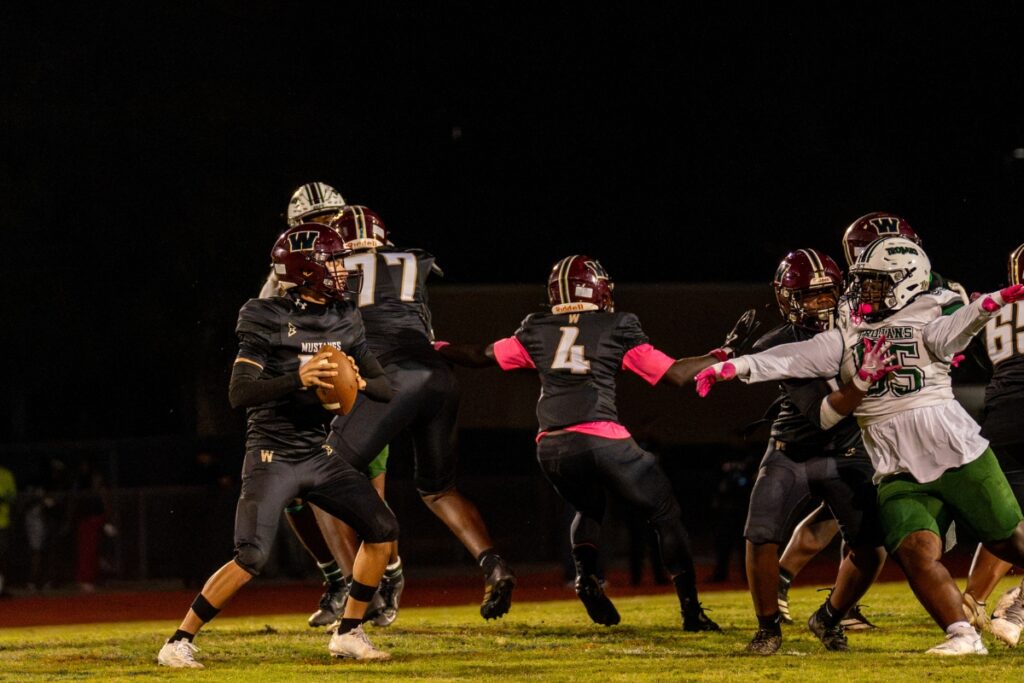Dominick Sanguine looks for an open receiver as an Evans pass rusher bears down on him Friday night.