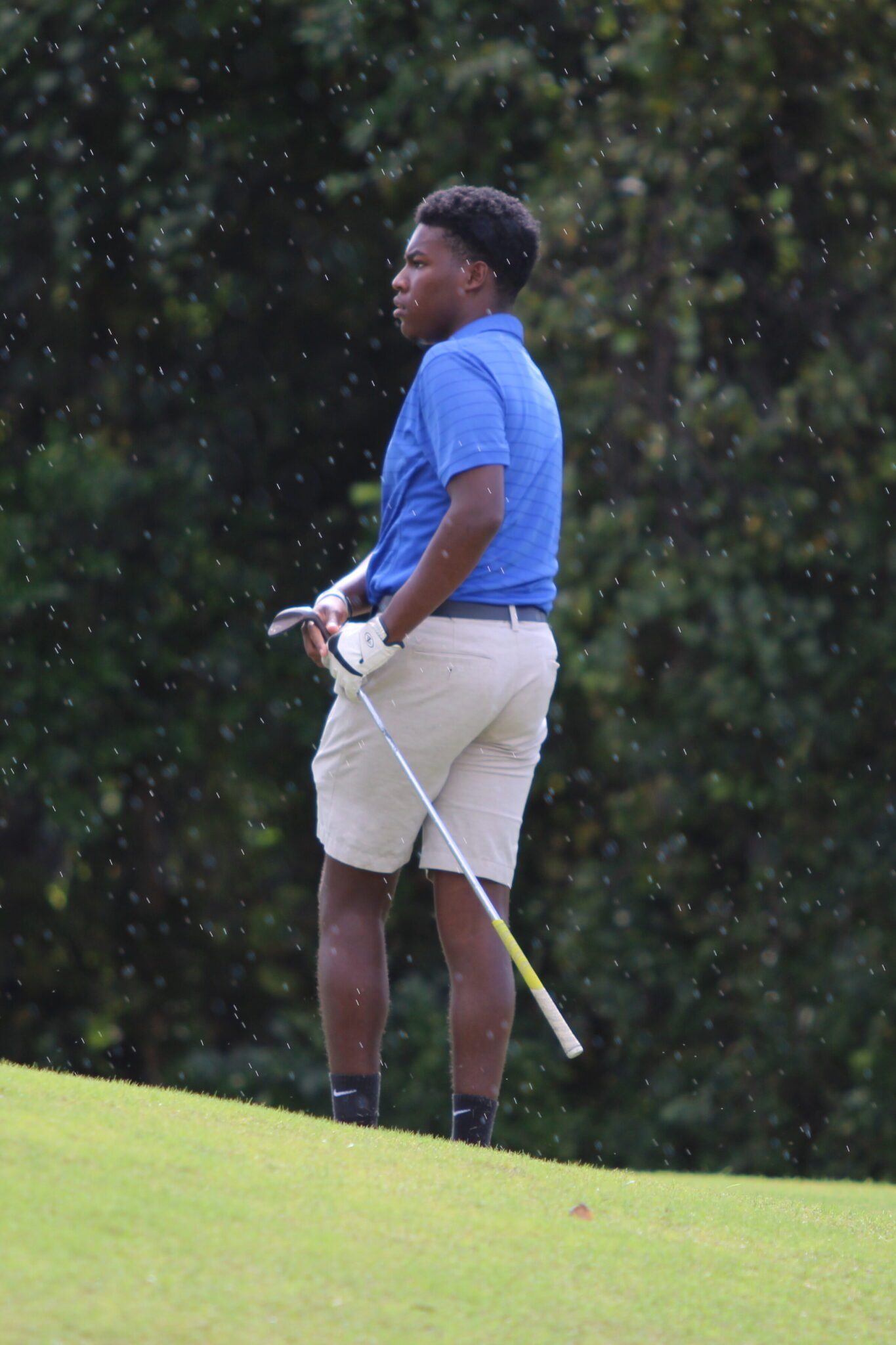 Kyler Ransom watches his ball fly through the rain.