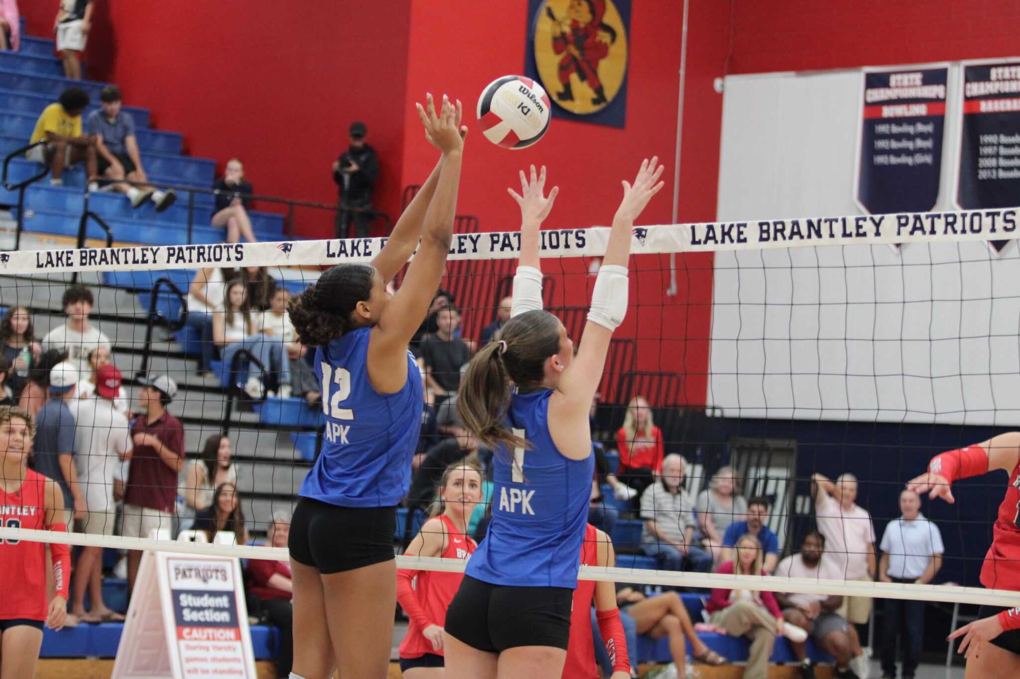 Laila White (12) and Taylor Cain (1) attempt to block a kill from Lake Brantley.