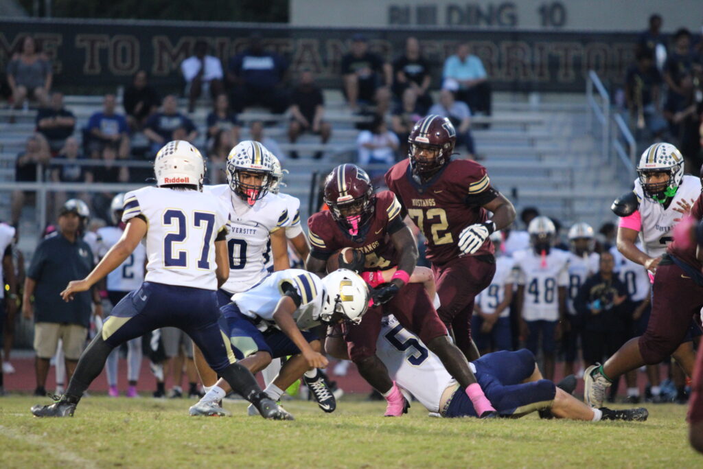 Landon Jerome fights through a pack of Cougars trying to bring him down.