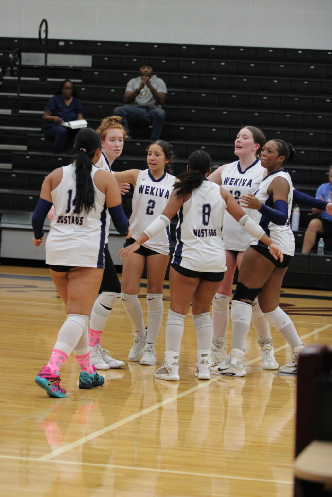 Mustangs huddle after Leona Salasek hits an ace.