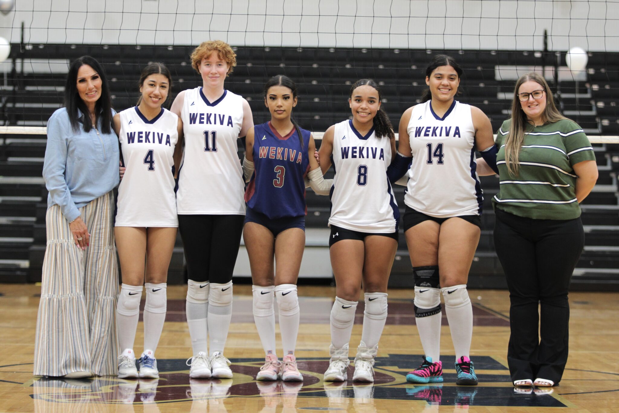 Senior Mustangs gather with their coaches for a group photo to end their senior night.