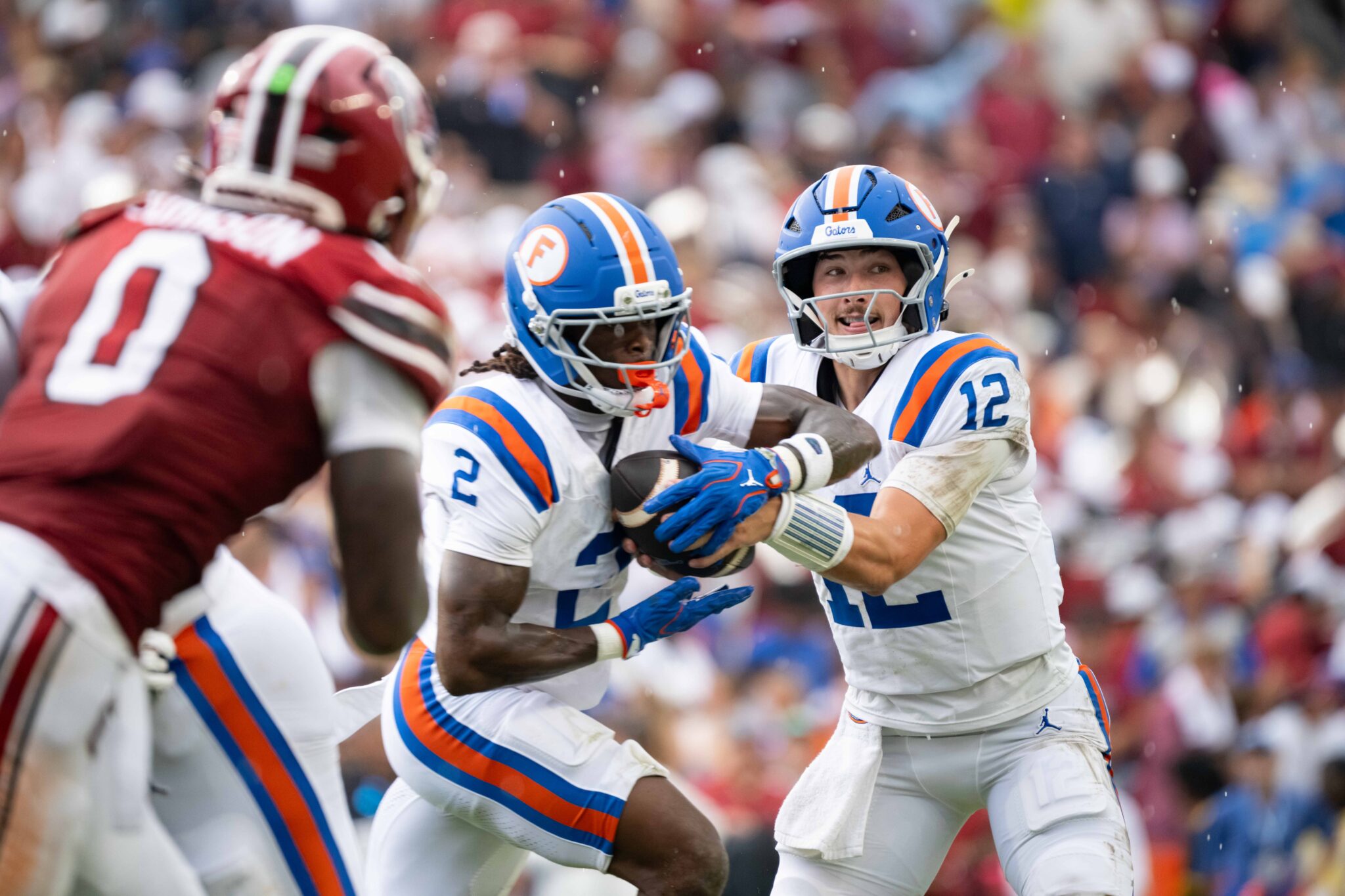 UF quarterback Aaron Philo hands the ball to wide receiver Eric Singleton Jr. during Saturday’s game against South Carolina