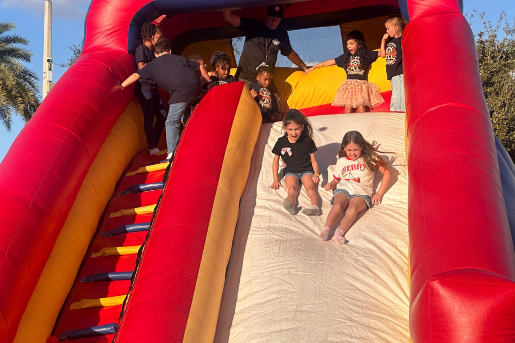 Children slide down an inflatable attraction during Central Florida Preparatory School’s fall festival Oct. 23 in Apopka. 