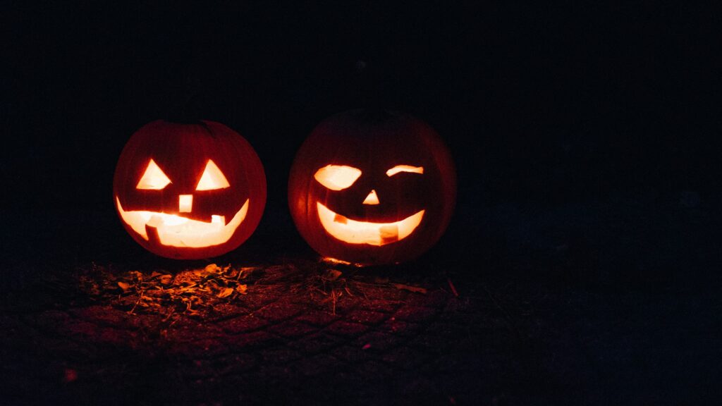 Two carved jack-o'-lanterns glowing at night